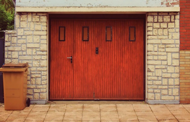 赤い扉の白いレンガ造りのガレージのある風景